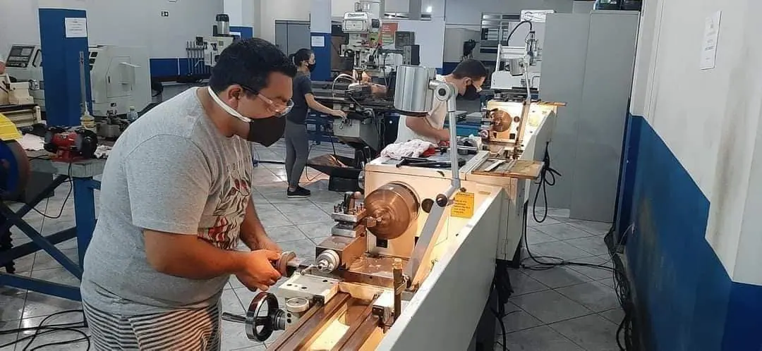 Aluno operando torno mecânico